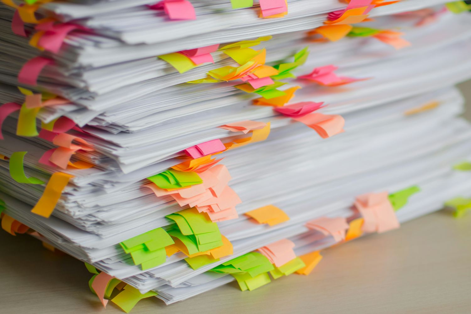 Stack of printed pages marked with coloured sticky tabs