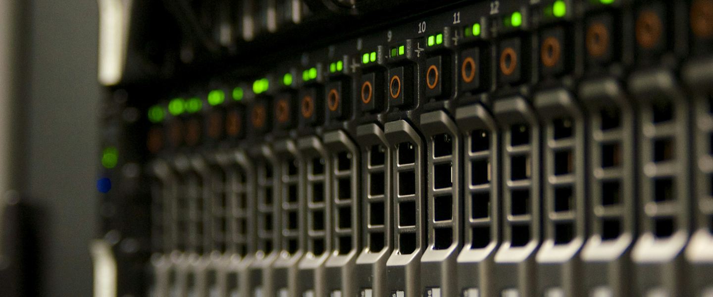 Row of server drive bays with green indicator lights in a rack