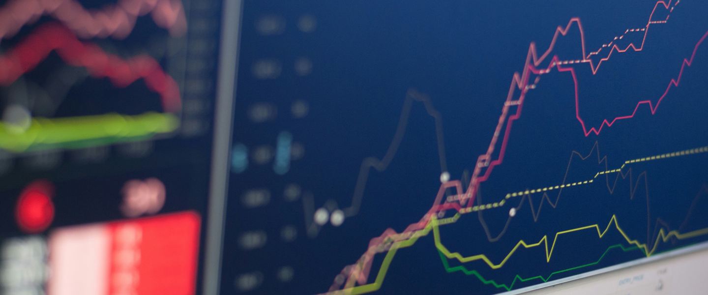 Price charts in several colours on trading screens, seen close up