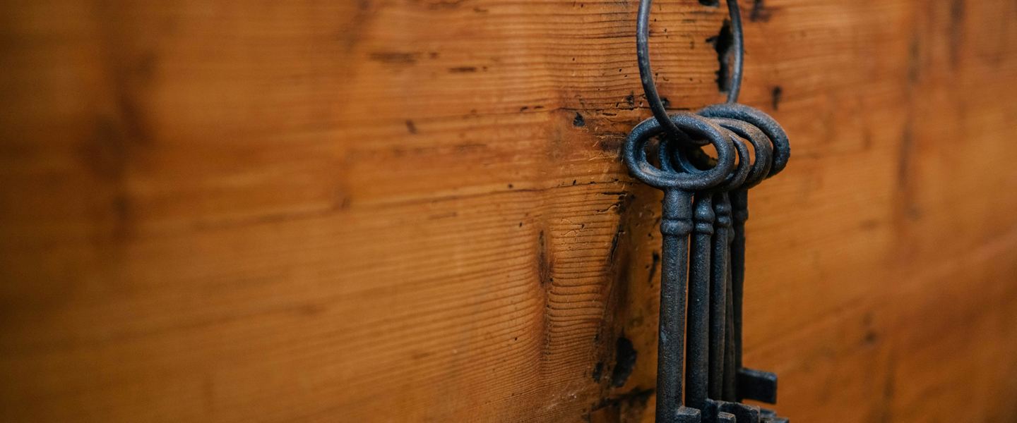 A ring of old iron keys hanging on a wooden chest
