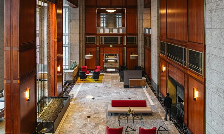 Tall marble and wood-panelled lobby seen from an upper level
