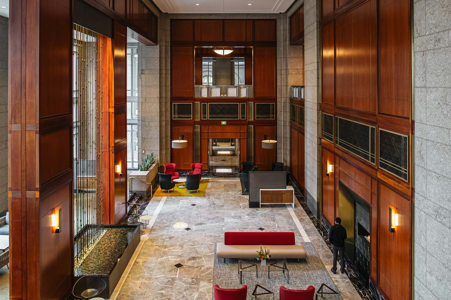 Tall marble and wood-panelled lobby seen from an upper level